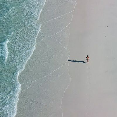 A woman running alongside the shore 