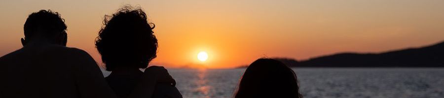 three silhouettes in front of a whitsunday island sunset