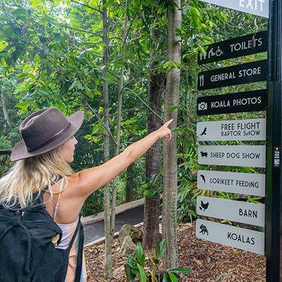 A woman pointing at a sign at the koala sanctuary