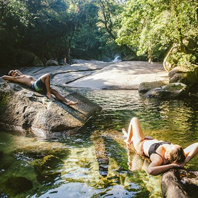 people lounging on rocks by Babinda Boulders