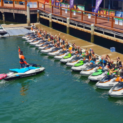 Jet ski instructor demonstrating safety hand signal to group