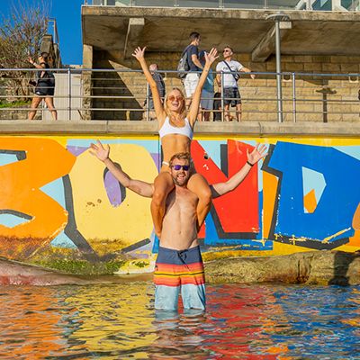 couple posing in front of colourful street art in Bondi