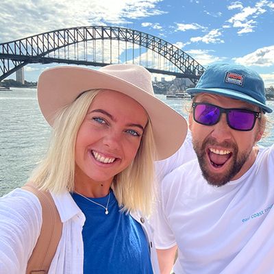 people taking a selfie in front of sydney harbour bridge