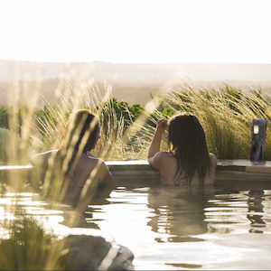 A couple chilling in a hot spring at Mornington Hot Springs