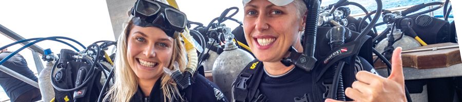 two girls preparing to scuba dive on the great barrier reef