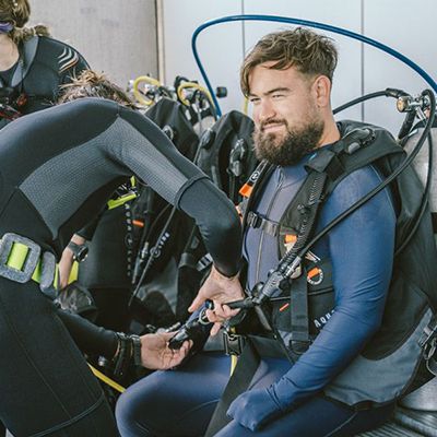 people putting on scuba diving gear