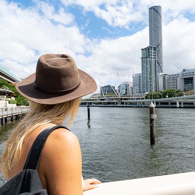 A woman with in a hat approaching the Brisbane River