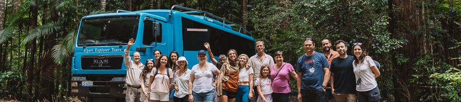 group tour in front of blue kgari explorer tours bus