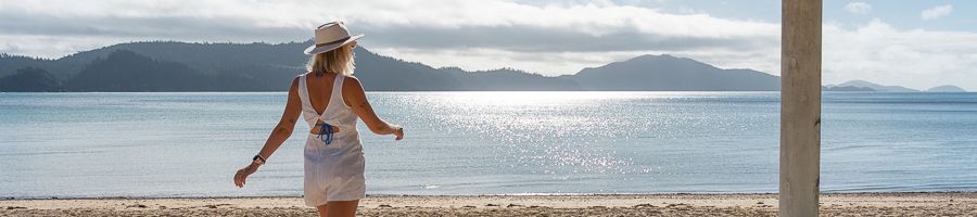 woman walking along the beach on long island whitsundays