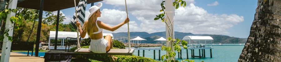 A woman on a swing by the water in a resort