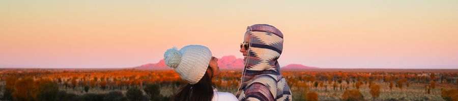 couple posing at sunrise in front of outback scenery