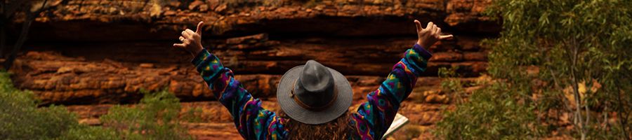 girl with hat posing in front of red rocks at kings canyon