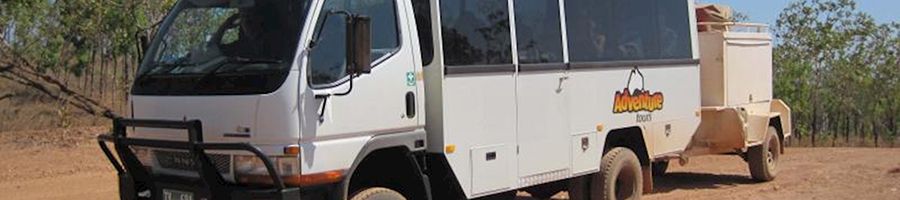 4wd bus parked on red dirt in the australian outback