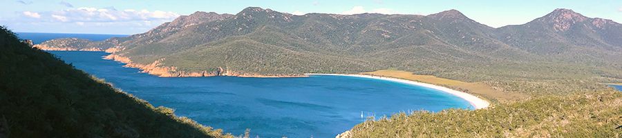 Wineglass Bay view with mountains, blue waters and white sands