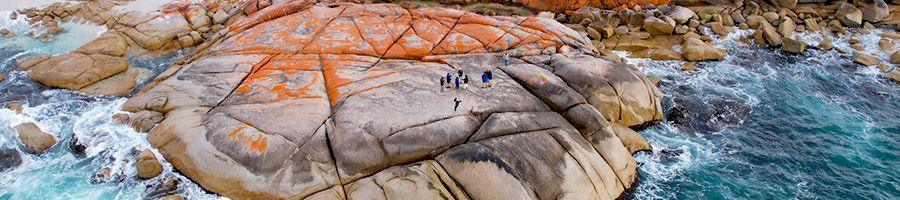 People standing on the shores of Bay Of Fires