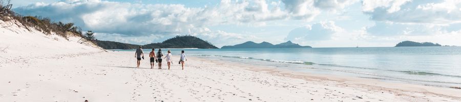 travellers walking along south whitehaven beach