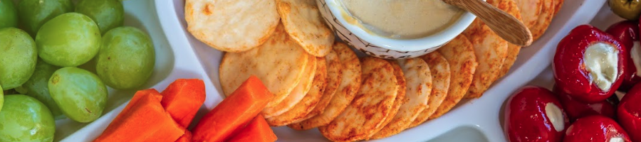 A close up image of a fruit, cheese and crackers platter