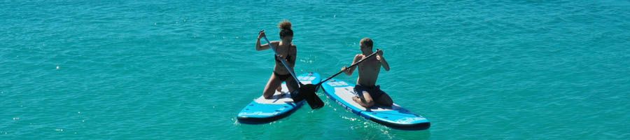 Two people in the ocean on paddle boards