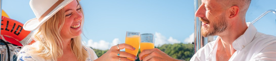 A man and woman holding up champagne glasses on a boat