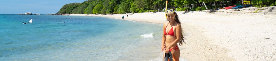 girl smiling with snorkel gear on a tropical island