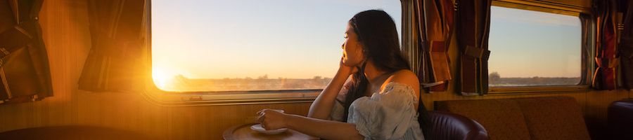 woman admiring sunrise on the ghan train outback australia