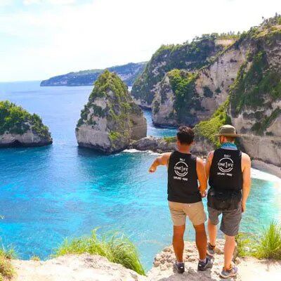 two travellers admiring rocky beaches on nusa penida