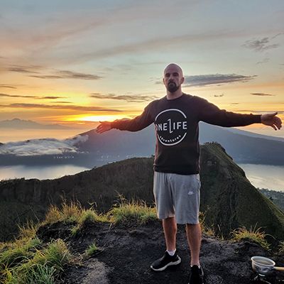 man standing on mount batur at sunrise in bali