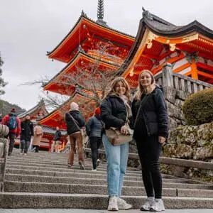 two travellers smiling in front of sensoji temple tokyo