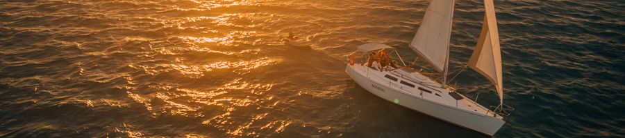 Domino sunset sail vessel in calm seas