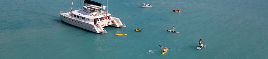 people trying water sports around a catamaran