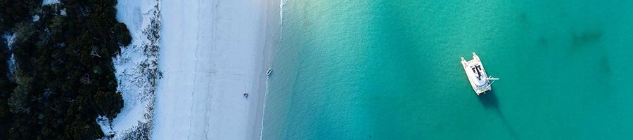 catamaran in the blue water near whitehaven beach