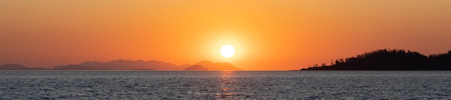 sunset over the mountains and ocean of the whitsundays