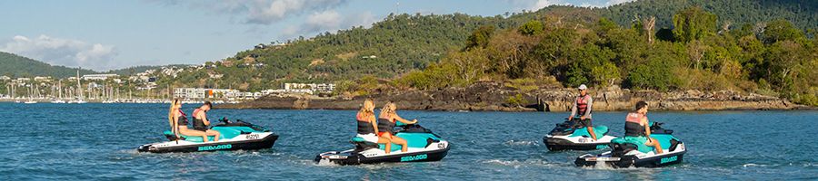 people on jetskis in the water near airlie beach