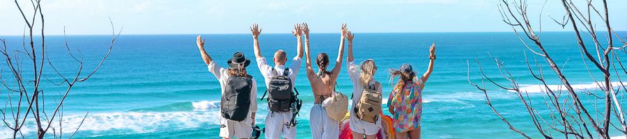 travellers posing on the edge of the ocean on kgari