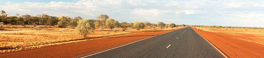 road traveling through the red desert of the outback