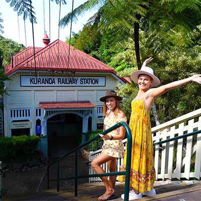 two girls posing next to kuranda railways station