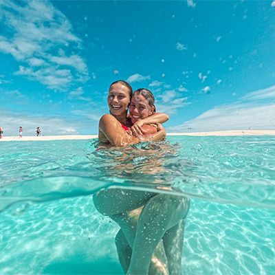 two people hugging on a tropical beach near cairns