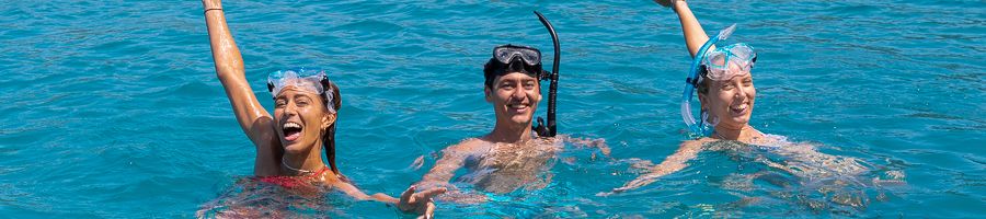 three people snorkelling in the ocean in australia