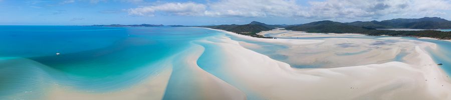 A drone shot of a the ocean, an island and sand