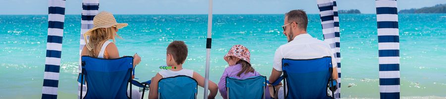 A family sitting under a cabana on a beach