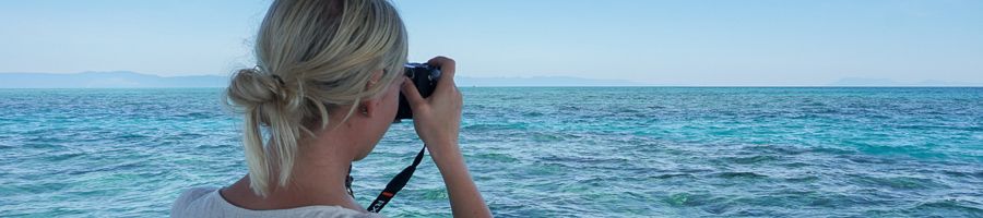 girl taking a photo of the tropical scenery over great barrier reef