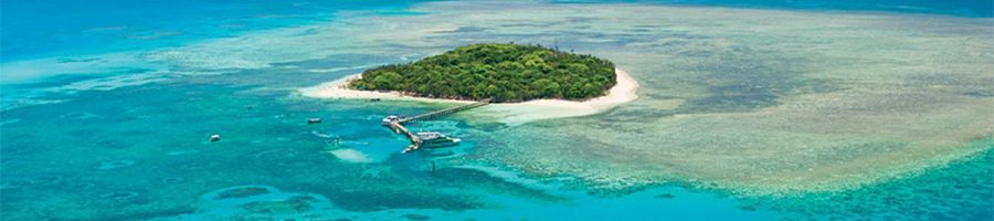 green island surrounded by coral reefs and ocean