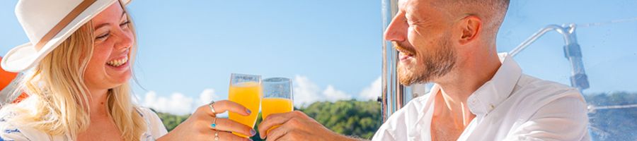 couple drinking orange drinks from flutes on a charter