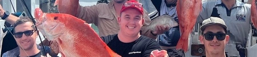 A group of men showing off their catches after a fishing charter in the Whitsundays