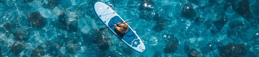 person on a paddleboard in blue water 