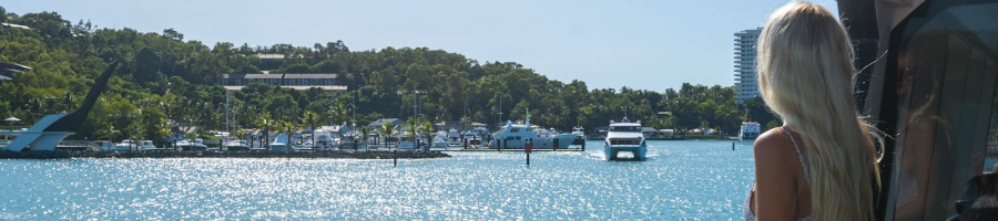 A woman standing on a ferry looking at Hamilton island