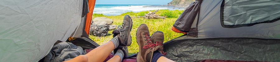 people with hiking boots lying in a camping tent