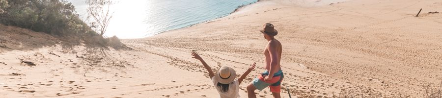 two people standing on sand dunes and posing