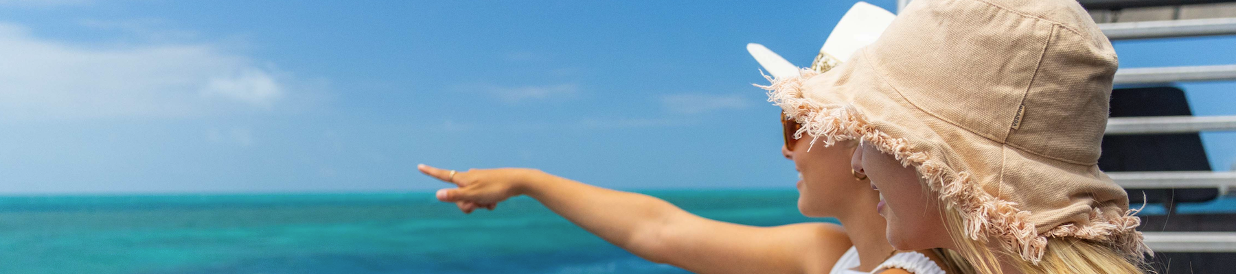 Two women pointing out to sea